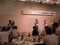 AA前日の記念祝賀会にて新潟の銘酒の手ゼリを行う佐藤一男流通委員長と遠山博文AA委員長。他県JU関係者との賑やかな交流に海津理事長も加わる、同JUの交流の広さが表れた1コマ。