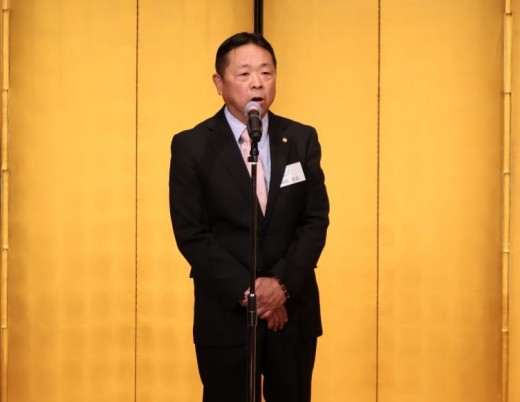 総会後の交流会であいさつに立つ塚田会長