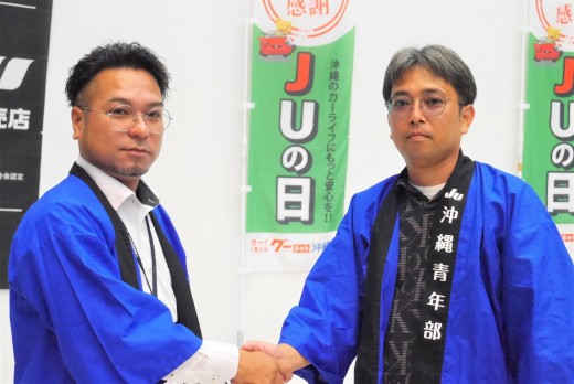 新旧青年部会長が固い握手（左から桃原部会長と池宮城淳前部会長