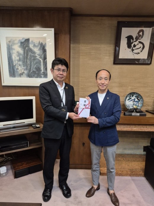 宮崎会場長（写真左）が広瀬市長に目録を手渡した