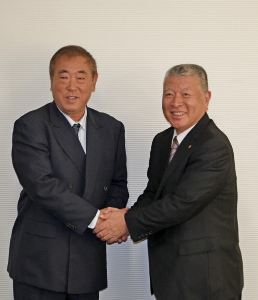 握手を交わすシティライト丸山明社長とＪＵコーポレーション喜多俊夫社長