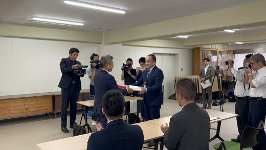 高木社長（写真左）が河野幸浩校長に寄贈品を手渡した