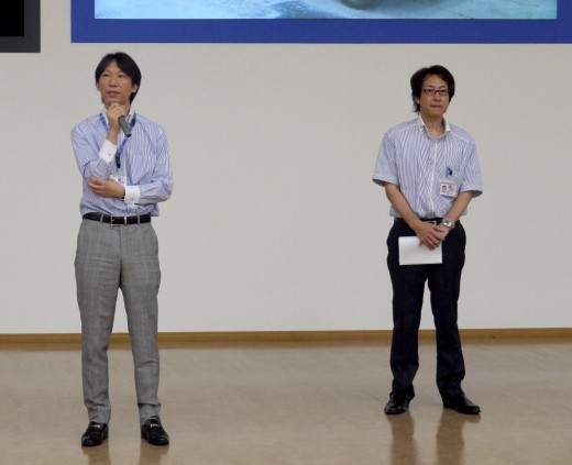 ＵＳＳ－Ｒ開設８周年記念ＡＡで挨拶に立つ瀬田大社長（写真左）と新美幸夫ゼネラルマネージャー