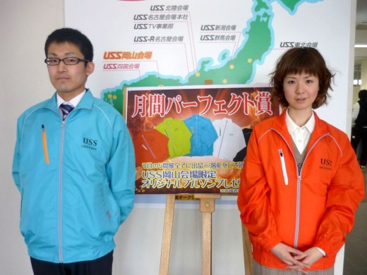 月間キャンペーンで進呈するオリジナルブルゾンを紹介するスタッフ 左から石原敬三氏、長田尚子さん