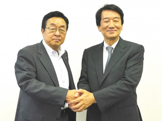 二村義春前理事長（写真左）と固い握手を交わす安部英雄新理事長（同右）