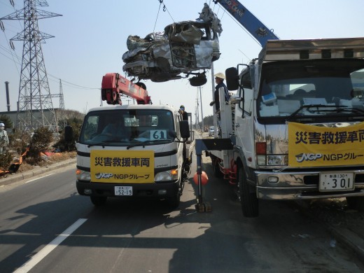 被災車両は異物付着で重量が超過状態。そのため大型のクレーン車で吊り上げ、中型車で移送という方法も。