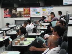 セリに参加するBA会員。前方スクリーンと手元リストを参照している。