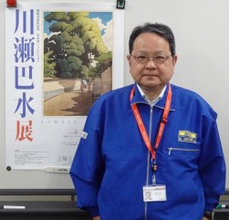 同展ポスターを前に荒井会長