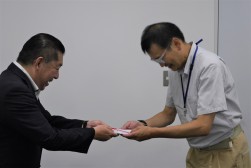 矢谷取締役（写真左）が尼子局長に寄付金の目録を手渡した