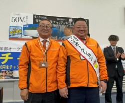 萩田理事長（左）から関連協リレーのたすきを受けた田中流通委員長