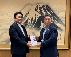 堀内常務理事（右）が神谷市長に目録贈呈