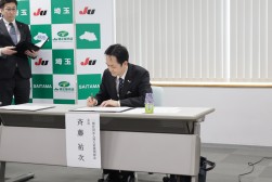 協定書に署名する斉藤理事長