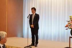 懇親会であいさつに立つ岡会長