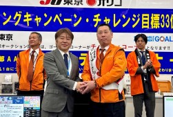 ＪＵ関連協の吉沢流通委員長（左）がＪＵ東京の沓澤流通委委員長にたすきを掛けた