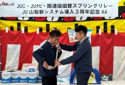 長田副理事長（左）に日向理事長がリレーのたすきを託した