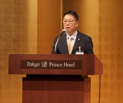 総会後の懇親会であいさつに立つ塚田会長・理事長