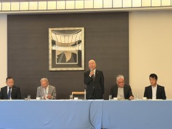 あいさつに立つ稗田金融委員