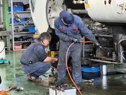 外国人と日本人が一緒に整備作業を行う（マンザイ自動車）
