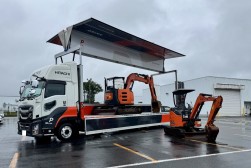 会場正面に日本に１台のプロモーショントラックと建機２台展示
