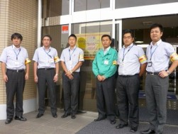 着用確認ポスターと腕章をつけたスタッフ