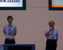 セレモニーで挨拶に立つ右）北野会場長・左）丸尾チーフマネージャー