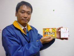 無料配布するカイロと干支石鹸を紹介するスタッフ（村田太氏）