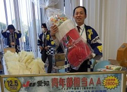 賞品の超巨大クリスマスブーツを持つ青年部の加藤久義氏