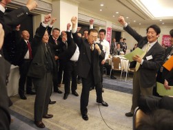 安部英雄金融委員長の上方修正発表に怯むことなく、拳を突き上げる第３支部会員