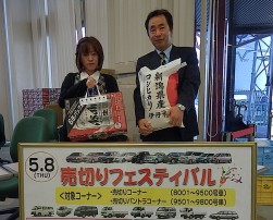 売切りフェスティバルの賞品を紹介するスタッフ（右から石原幸一検査副委員長、佐藤理香さん）