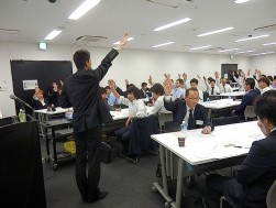 アップルアカデミーでの発表は全員が挙手するのが慣習（挙手を促す半田氏と力強く挙手する講義参加者）