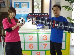 キックターゲットで応援グッズなどをプレゼント、営業室の服部祥平主任（写真右）と勝野夏子さん（写真左）も日本代表を応援