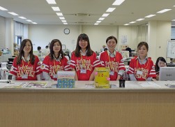 イベント開催当日、ＳＢのユニホーム（イベントコスチューム）を着用し笑顔で会員を出迎える女性スタッフ