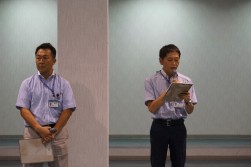 挨拶に立つ江越孝志課長代理（写真右）