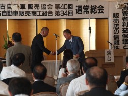 握手する金子新理事長と土屋理事長（退任役員表彰にて）