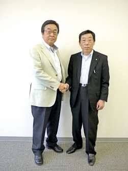 バトンを渡した二村義春理事長と握手を交わす上松倉人名誉会長