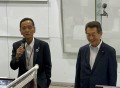 佐藤副理事長（左）が海津会長の横であいさつ