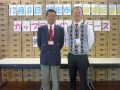 山積みされたカップラーメンの前に立つ大塚会場長