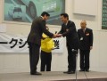 桜木金融委員長（写真右）が表彰状を手渡した