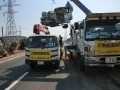 被災車両は異物付着で重量が超過状態。そのため大型のクレーン車で吊り上げ、中型車で移送という方法も。